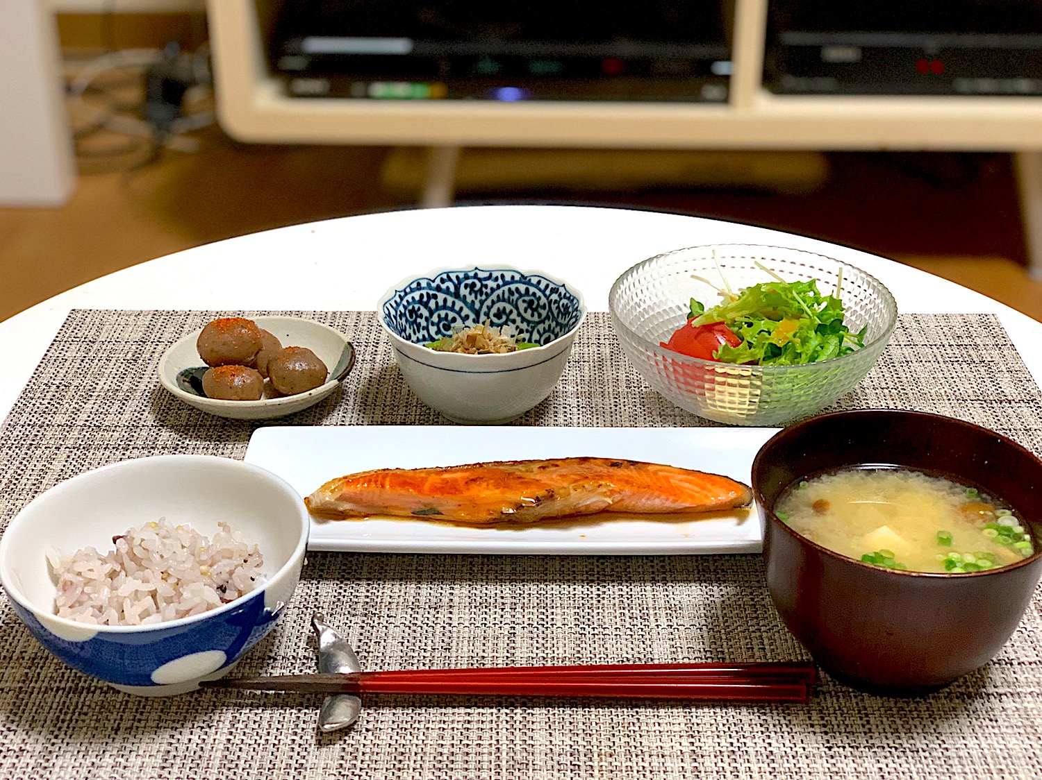 晩ごはん。鮭のバター醤油焼き、なめこと豆腐の味噌汁、玉こんにゃく、ほうれん草のおひたし、野菜サラダ、雑穀ごはん。