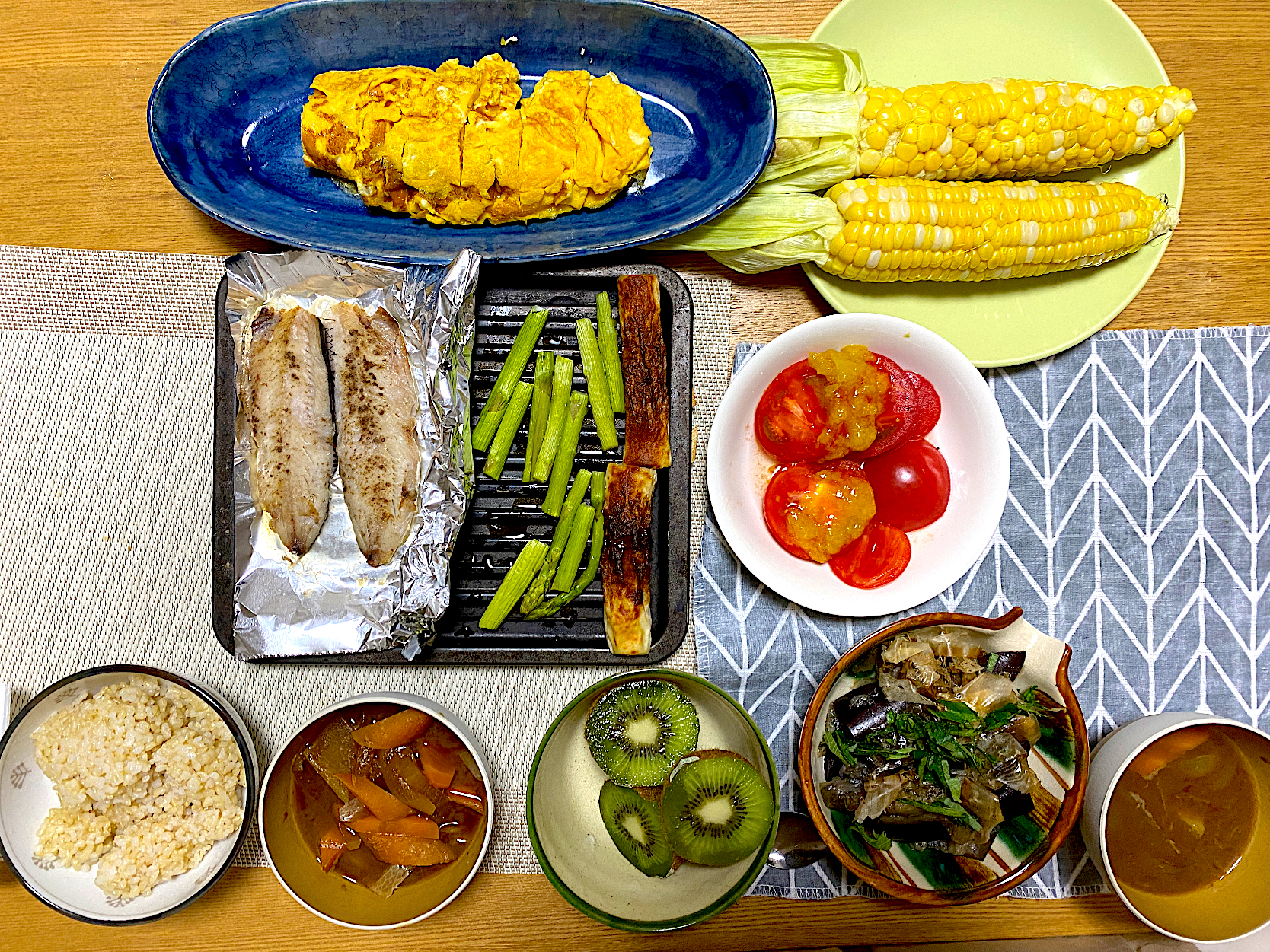 卵焼き🥚、蒸しとうもろこし🌽、飛び魚焼き🐟、アスパラとちくわのグリル、味噌汁、今井真実さんの梅ピュレトマト🍅、キウイ