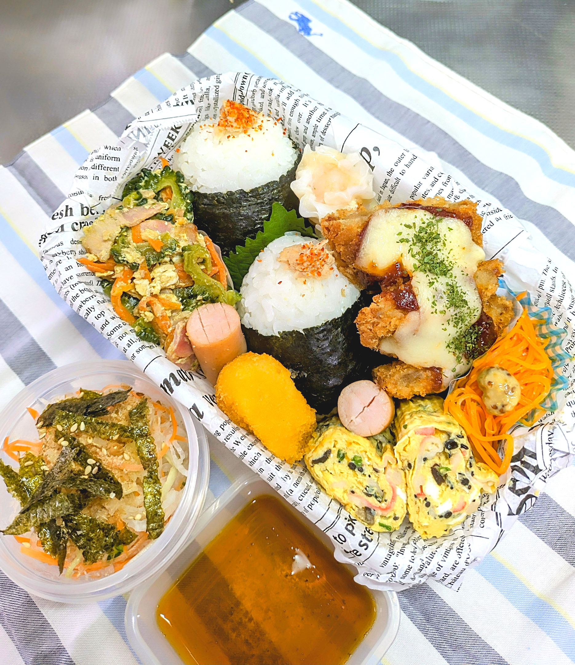 本日の日替わり弁当

①ツナマヨおにぎり
②デミチーズヒレカツ
③ポキポキウインナー＆海老シュウマイ
④厚焼きたまご（かにかま・青ネギ・ひじき）
⑤コーンクリームフライ
⑥キャロットジンジャー粒マスタード添え
⑦母作 ゴーヤーチャンプルー
⑧大根サラダ（青じそドレッシング）